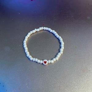 White beaded bracelet with a heart in the middle